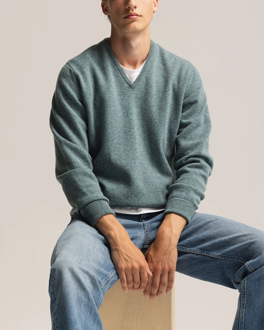 Grå v-ringet sweater og blå jeans